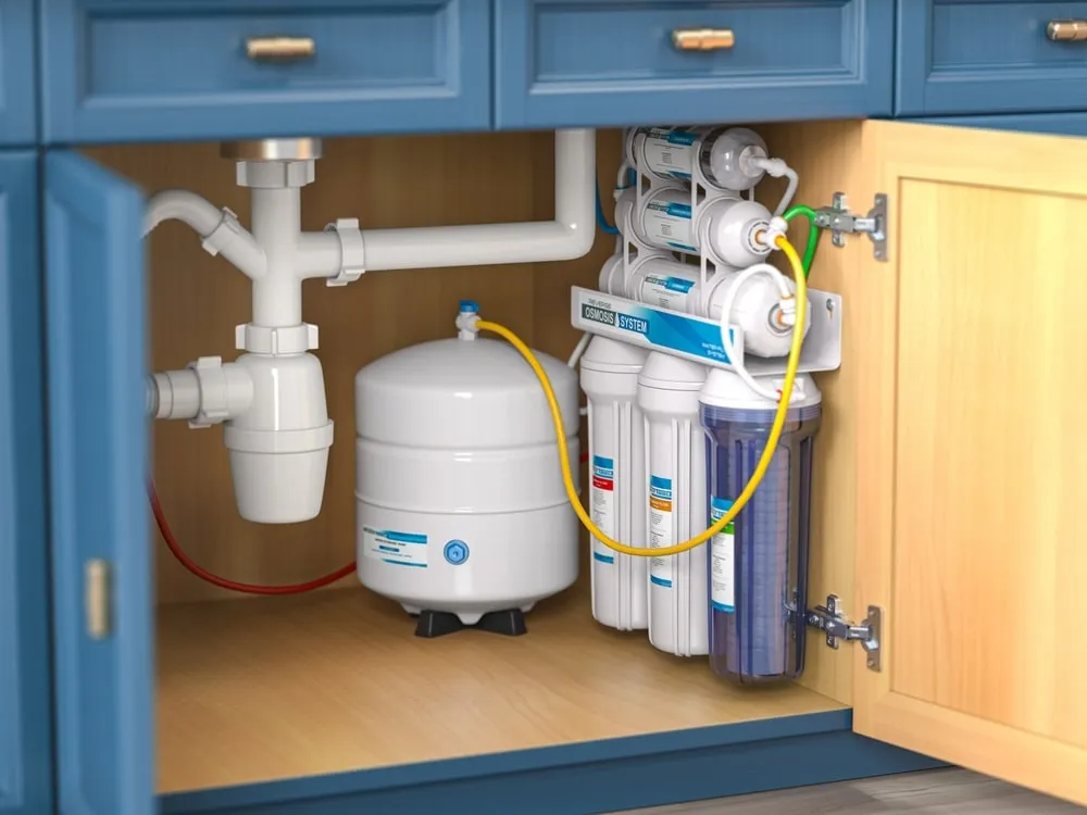 Under-sink reverse osmosis unit being serviced by a plumber