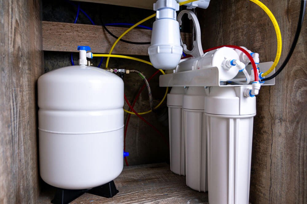 Technician installing a water filtration system in an Oceanside, CA home